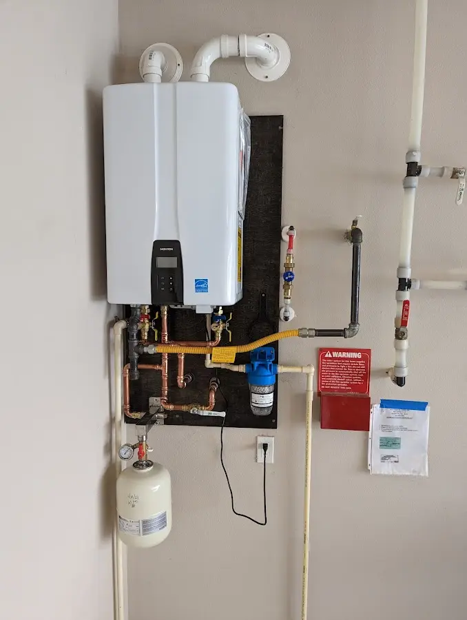 Professional plumber installing copper piping in a Lower Milford home